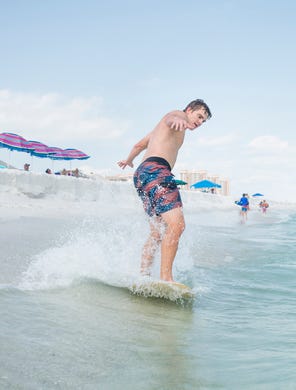 Pensacola News Journal sports reporter Eric Wallace gives skimboarding a try along Penacola Beach on Friday, July 20, 2018.