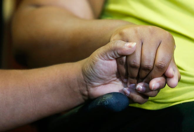 Tia Coleman, right, a survivor of the Ride the Ducks incident on Table Rock Lake on Thursday, July 19, 2018, holds hands with her sister Yelena Brackney during a press conference at Cox Medical Center Branson on Saturday, July 21, 2018. Coleman lost 9 family member in the tragedy.