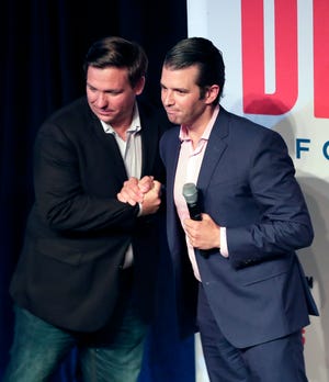 Donald Trump Jr., right, greets Florida gubernatorial candidate U.S. Rep. Ron DeSantis at a campaign rally Wednesday, July 18, 2018, in Orlando.