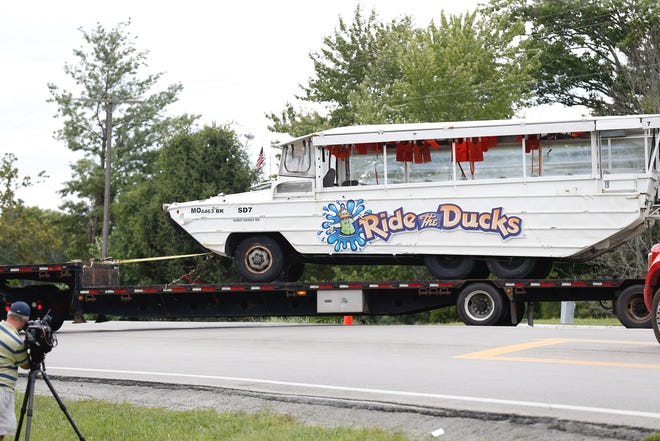 The capsized duck boat is being hauled away on a flat bed trailer down Missouri 265 on Monday, July 23, 2018 in Branson, Mo.