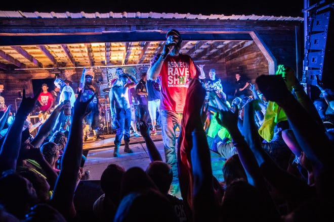 Redneck Rave creator and music artist Justin Stowers performs with other country rap artists during the Redneck Rave at BlackSwan Mudpit in Medora, Ind., on Friday, July 20, 2018. Stowers, a self proclaimed city-boy from Fort Wayne, Ind., started the Redneck Rave in 2016. "I was working at Arby's and cutting grass. Saved up some money so I could throw a little party," he said. "A buddy came up to me and said 'man, you should throw a county party.' I was like alright, I'll try it."  The most recent event marks the 19th Redneck Rave. 