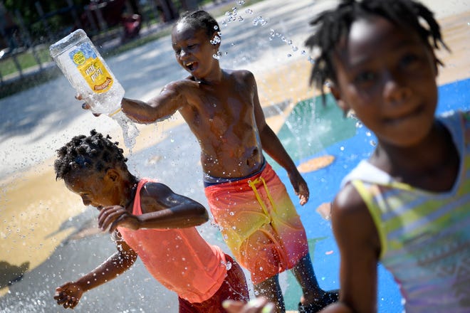 Leon Dixon, 10 dumps water on Jamika Smith, 6, while playing in the Penn Park splash pad in York City, Tuesday, July 10, 2018. John A. Pavoncello