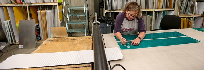 Kitsap County streetsign fabricator Lynn McLean cuts out the letters from the vinyl while making a road sign for Forest View Lane SE on Thursday, August 2, 2018. 