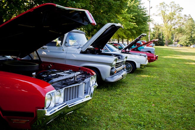 Raised hoods  showcase engines  of vintage cars at summer car show.  USA  1970's vehicles.