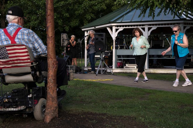 (from right) Alice Smith and Helen Kubik line dance as Due South performs during a concert at Wilmore Road Memorial Park on Thursday, August 2, 2018.