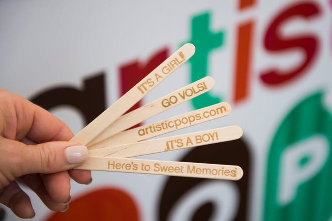 Kristina Killebrew holds custom popsicle sticks at the Artistic Pops stand Saturday, Aug. 4, at the farmers market in downtown Knoxville. Artistic Pops are gluten-free, nut-free and dairy-free popsicles.