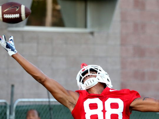 Receiver Tre Adams stretches but can't get to a high throw as he runs route drills at the first day of practice for the University of Arizona, Friday, August 3, 2018, Tucson, Ariz.
