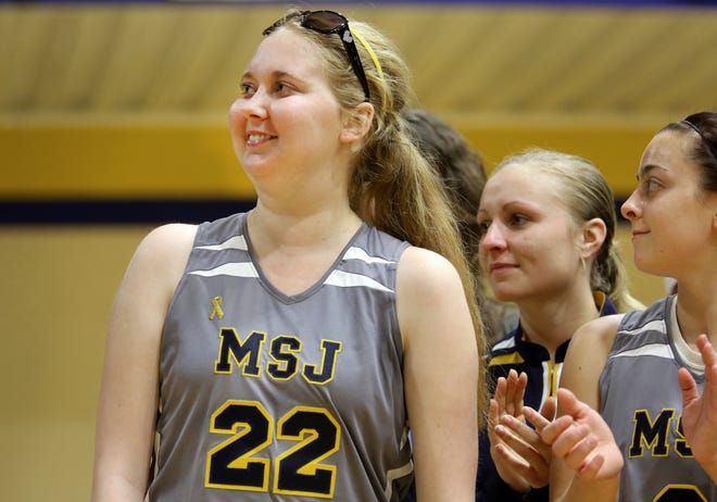 Saturday, Dec. 13, 2014
Lauren Hill, a freshman on the Mount St. Joseph women's basketball team, reacts to the applause, as she is honored following the team's opening game at Harrington Center. Even though the team lost to Franklin College, 68-56, anytime Hill can be part of the team, it's a celebration. Hill has been battling DIPG, a form of brain cancer for the past year. She is terminal. She has become the poster girl for The Cure Starts Now Foundation and has helped raise thousands of dollars for research. Hill shot one layup at the beginning of the game.