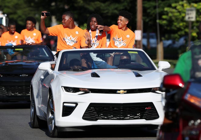 (Right to Left)  Isaiah Green, Stevaun Butler and T.J. Ladd waved at the crowd as they cruised down West Broadway during a parade to celebrate the 13 and Under West Louisville All-Stars advancing to the Babe Ruth World Series in Arkansas.Aug. 6, 2018