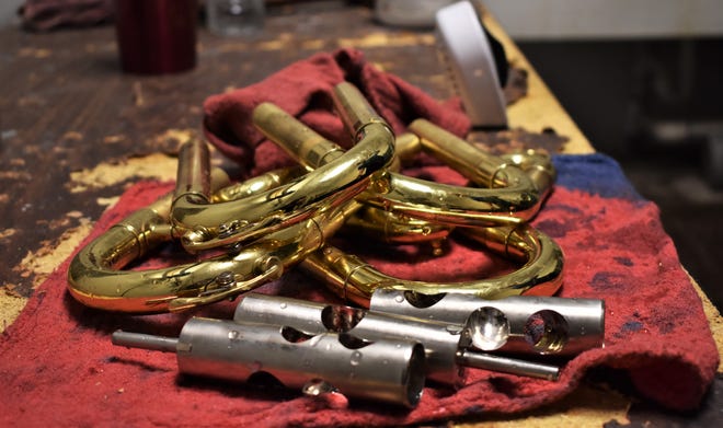 Various parts of brass instruments sit on a workbench after being cleaned on July 30, 2018 at Tarpley Music.