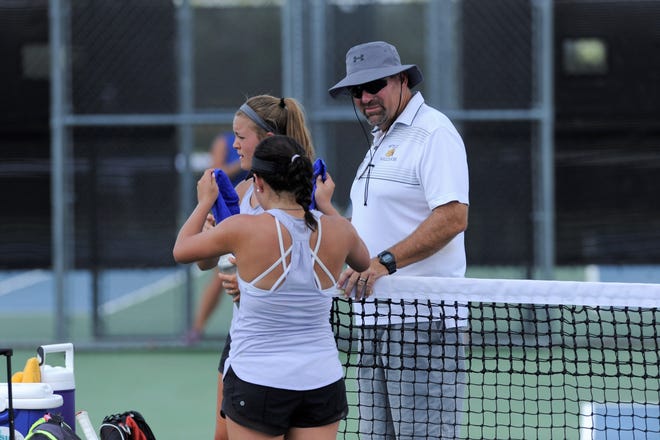 First-year Wylie tennis coach Mark Hathorn talks with Leighton Alford and Analeah Elias during their girls doubles match against Midlothian. Hathorn took over the program after spending the last 17 years at McMurry. Hathorn's three daughters all played tennis at Wylie.