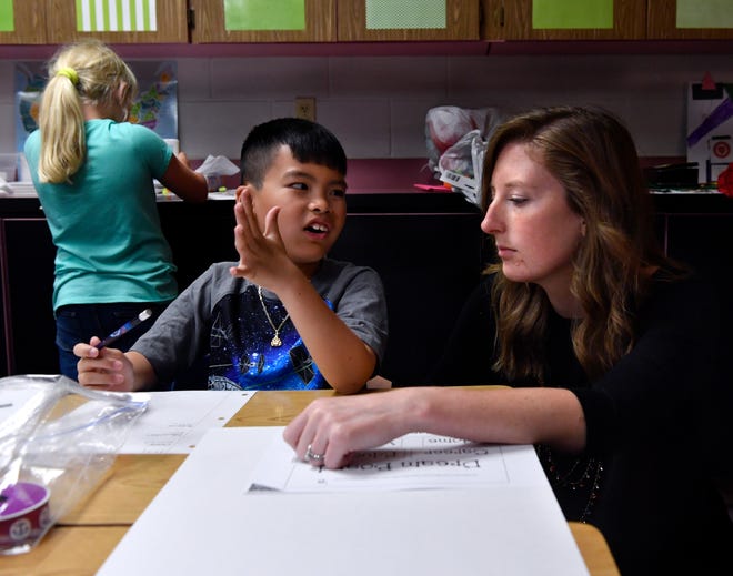 Allie Ward Elementary School third-grader Andy Phan is assisted by his teacher Kaitlin Hoermann with an assignment May 24.