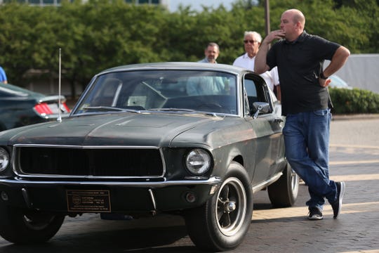 Sean Kiernan of Nashville stands next to the Ford Mustang GT 390 driven by Steve McQueen in the cult classic film "Bullitt." Kiernan's family has owned the car since 1974. Here, it was part of the 10 millionth Mustang celebration at Ford World Headquarters in Dearborn on Aug. 8, 2018.