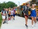 Students race off the buses at the new McCutchanville Elementary school for the first day of school Wednesday, August 8, 2018. 