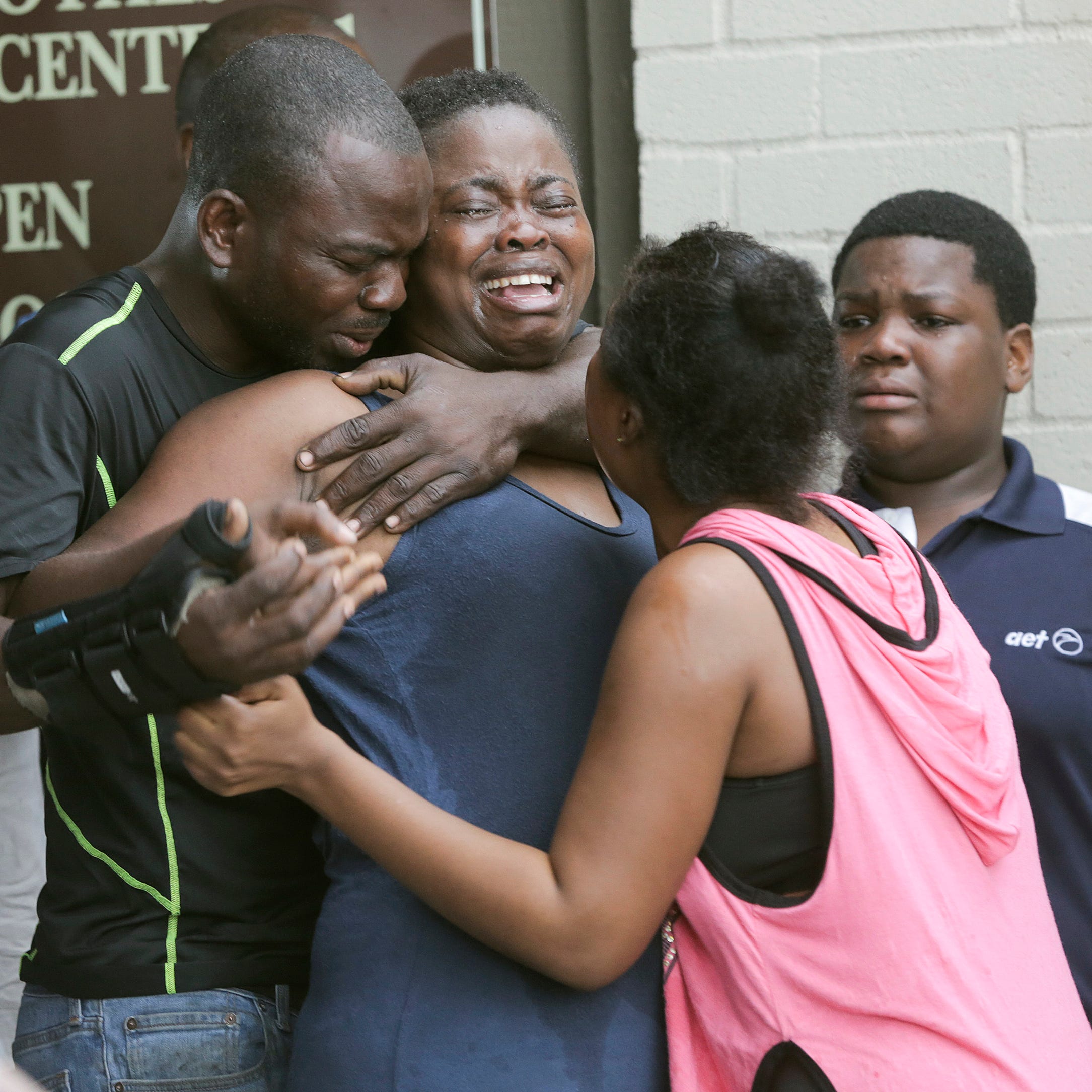 A woman is comforted after the bodies of two children were found stabbed to death in their father's apartment on Saturday, Aug. 4, 2018 in Houston. Authorities say a man suspected of fatally stabbing his two children in Houston has been hospitalized 