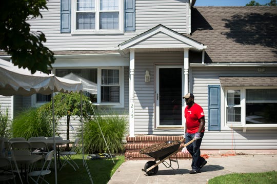 Shaheed Sellers, a volunteer with Lowe's, works to rehab the yard of the Kenny Smith Freedom House, a sober living home Friday, Aug. 10, 2018 in Marlton, N.J.
