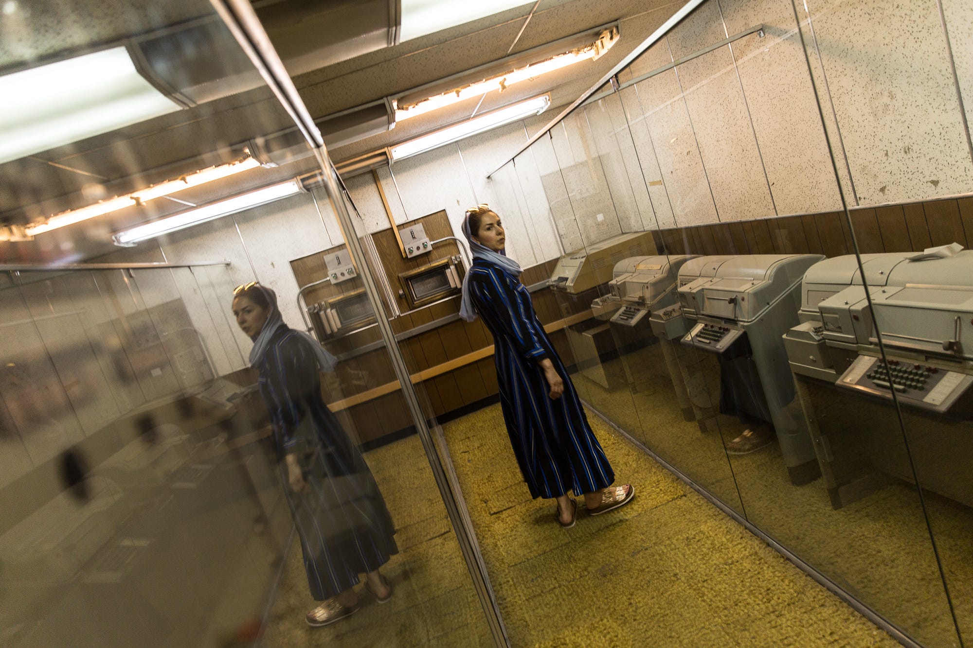 A woman inside the former U.S. Embassy in Tehran examines communication equipment abandoned by American diplomats in 1979 amid the nation's Islamic Revolution and the U.S. hostage crisis.