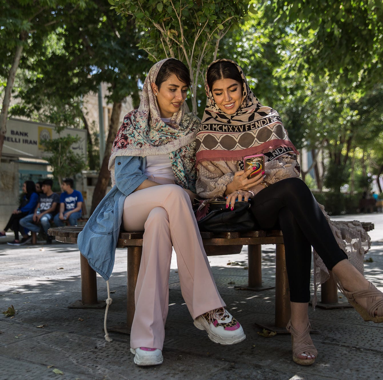 Kimia Naderzadeh, right, and her cousin, Maryam Dehnavi, sit in the shade on a pedestrian street in Isfahan, Iran, on July 13, 2018.