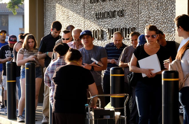 People line up outside a California Department of Motor Vehicles office prior to opening in Van Nuys on Tuesday. The DMV blames long wait times at its offices on underestimations of the time it takes to process "Real ID" applicants.