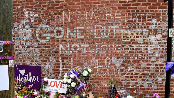 Messages written in chalk fill a brick wall where Heather Heyer was killed last year in Charlottesville, Va., on Saturday, August 11, 2018.
