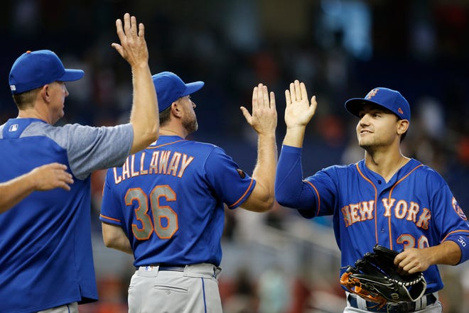 New York Mets left fielder Michael Conforto celebrates with manager Mickey Callaway and pitching coach Dave Eiland after their victory over the Miami Marlins.
