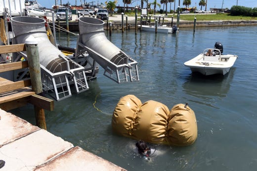 Levin Shavers, a member of the salvage crew with Maritime Research and Recovery, carefully removes the airbag used to float a cannon from the 1715 Spanish Plate Fleet before it is hoisted ashore on Monday, Aug. 13, 2018 at Fisherman's Wharf in Fort Pierce. The cannon, found off Sandy Point, will be treated and cleaned and put on display at Melody Lane Fishing Pier. The process will take about three years.