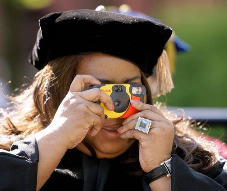 Performer Aretha Franklin snaps a photo of an academic procession before the University of Pennsylvania Commencement ceremony in Philadelphia, Monday, May 14, 2007. Franklin received honorary degree during the ceremony. (AP Photo/Matt Rourke) ORG XMIT: PAMR107