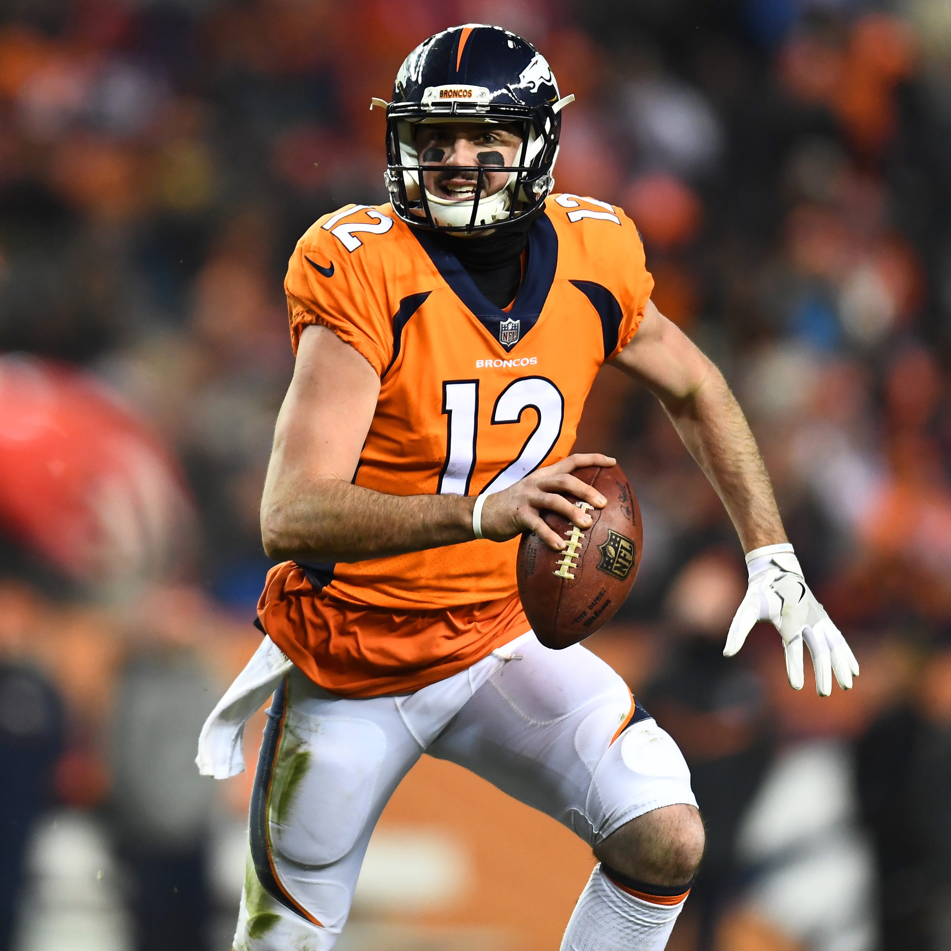 Denver Broncos quarterback Paxton Lynch (12) scrambles in the fourth quarter against the Kansas City Chiefs at Sports Authority Field at Mile High.
