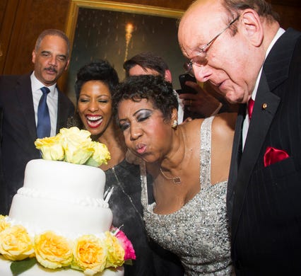 Aretha Franklin blows out the candles on her birthday cake accompanied by, from left to right, Attorney General Eric Holder, Tamron Hall and Clive Davis during Aretha's annual birthday bash at The Ritz Carlton on Sunday, March 22, 2015, in New York. (Photo by Charles Sykes/Invision/AP) ORG XMIT: NYCS108