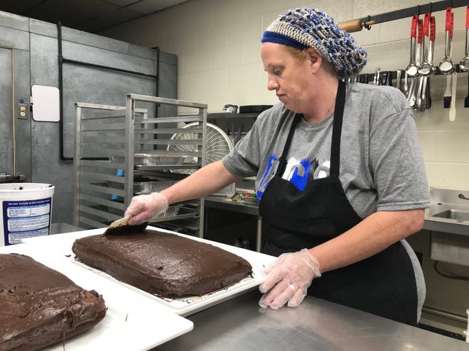 Shirley Smith, administrator of food service at Abilene Christian School, frosts a cake for decorating Tuesday. Smith returns to the private K-12 North Abilene school after a one-year absence much to her own delight and to that of some of the students.