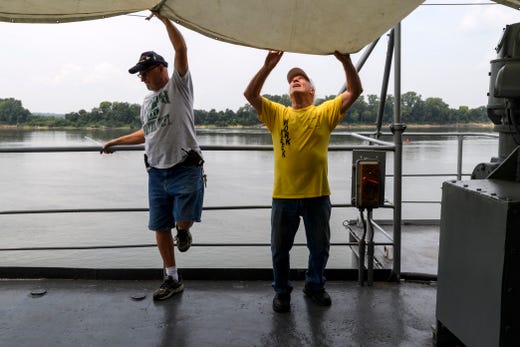 Scott Anderson of Evansville, left, and Dave Cassell of Cincinnati, Ohio, right, work with other volunteers to hang a canopy over a deck on the USS LST-325 in Evansville, Ind., Tuesday, Aug. 14, 2018. About 50 volunteer workers from all over the country will board the ship on Thursday for a month long sailing trip to Dubuque and Bettendorf, Iowa, and Chester, Ill., to educate the public about LST ships. 