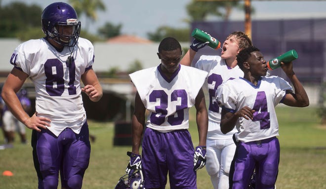 Cypress Lake High School football players take a break during a hot August practice.