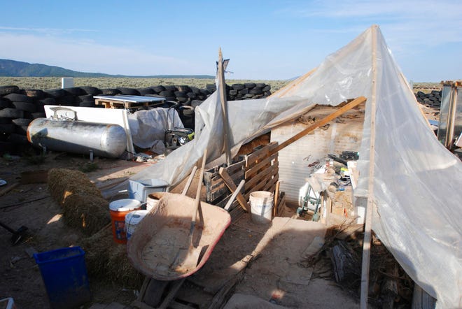 Various items litter a squalid makeshift living compound in Amalia, N.M., on Friday, Aug. 10, 2018, where five adults were arrested on child abuse charges and remains of a boy were found. The remains, which haven't been positively identified, may resolve the fate of Abdul-ghani Wahhaj, a missing, severely disabled Georgia boy. Eleven other children were found at the compound during a raid last week.