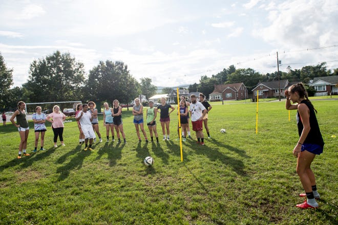 Fairfield girls soccer head coach Phomma Phanhthy, left, kicks the ball to Rio Strosnider while demonstrating a drill during the first day of fall sports practice on Monday, August 13, 2018. 
