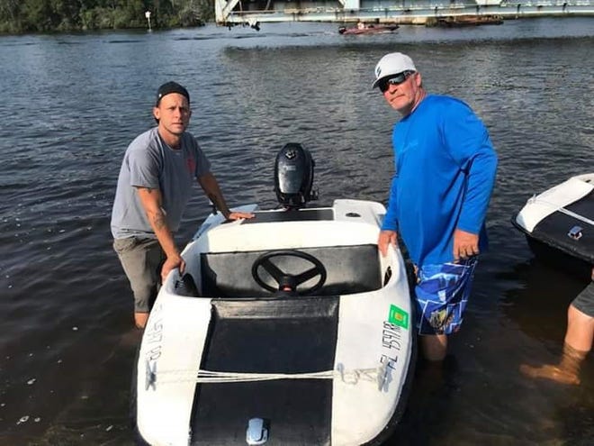 LILPAXS Mini Boats owner Mike Hudson, left, and his friend Bobby Whittmire pose near one of Hudson's mini speed boats he rents out from a location on the Blackwater River in downtown Milton.