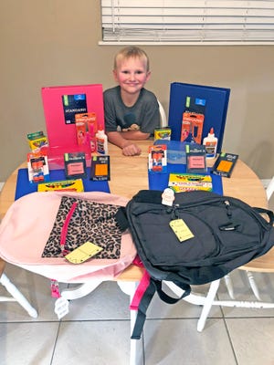 Corbin Odekirk preparing to fill backpacks for school children in need.