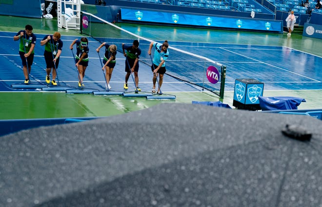 Volunteers squeegee the court during the Western & Southern Open at the Lindner Family Tennis Center in Mason, Ohio, on Thursday, Aug. 16, 2018.