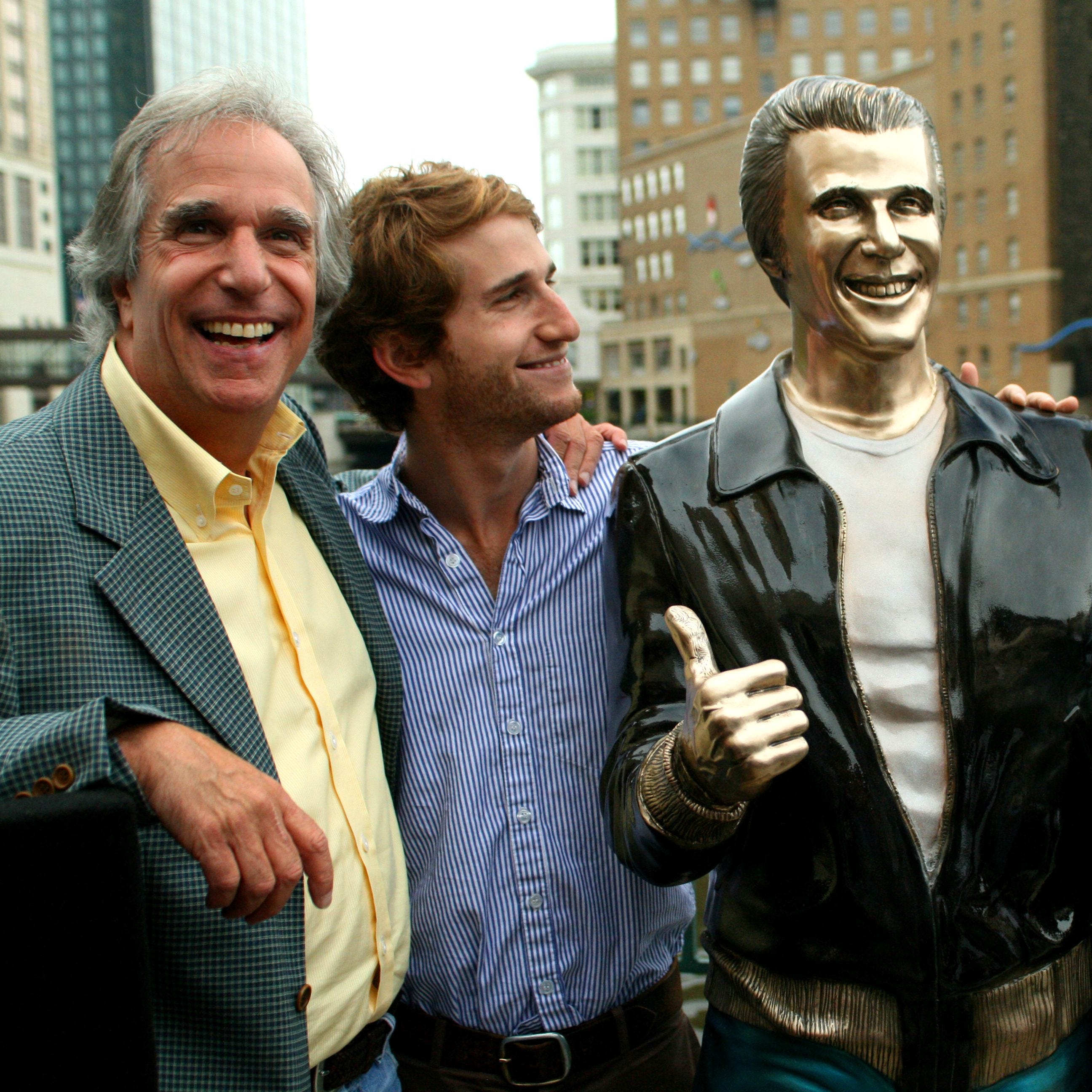 Actor Henry Winkler, left, poses with his sons Max Winkler, second left, and Jed Weitzman as they stand with a bronze statue of the 