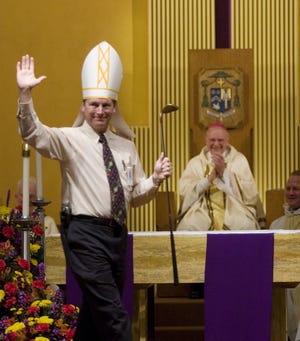 A 2008 photo of Troy Casteel, then-Director of Family Ministries for the Diocese, pointing out Bishop John Leibrecht's love of golf during a skit after Mass.