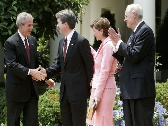 Brett Kavanaugh shakes hands with President George W. Bush after being sworn in by Supreme Court Justice Anthony Kennedy as a judge on the U.S. Court of Appeals for the District of Columbia Circuit on June 1, 2006.