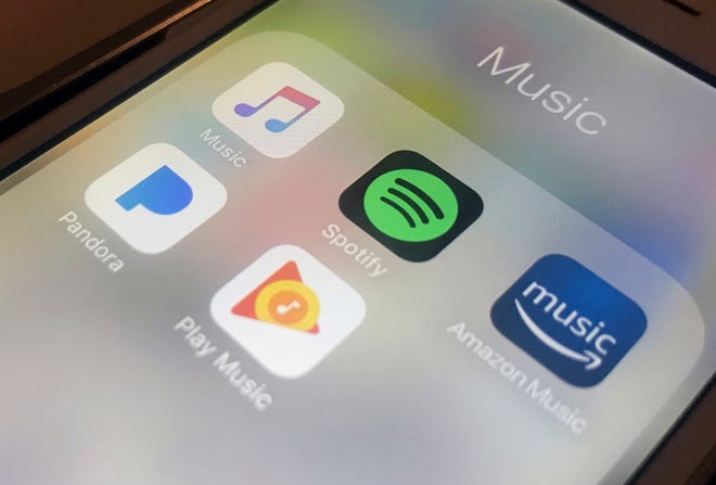 This Jan. 28, 2018, file photo shows music streaming apps clockwise from top left, Apple, Spotify, Amazon, Pandora and Google on an iPhone in New York.