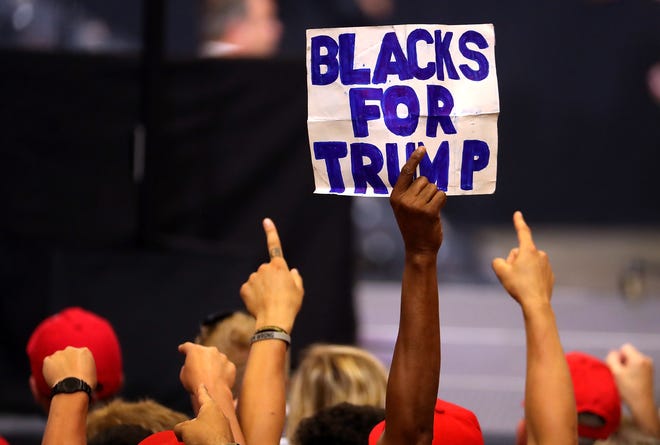 A suppoter holds a sign as President Donald Trump speaks during a campaign rally at Scheels Arena on June 27, 2018, in Fargo, North Dakota.