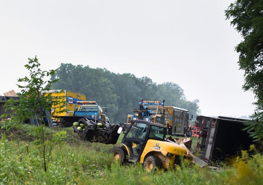 Workers clean up the scene of an accident Friday, Aug. 17, 2018, on westbound I-96 near exit 122 in Leroy Township.  Around 4:50 AM, a semi carrying watermelons sideswiped a disabled semi stopped along the shoulder according to Ingham County Sheriff Department officials.  The driver of the parked semi was taken to Sparrow with serious but non life-threatening injuries.