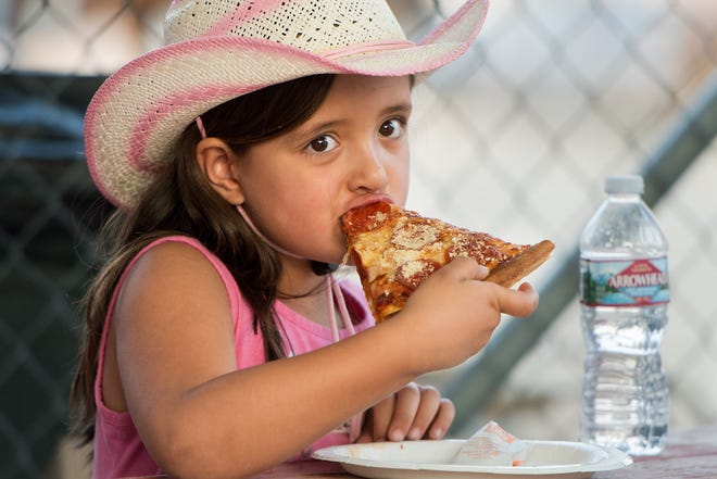 Harley Lassey, 6, from Yerington, enjoys a pizza at the fair.