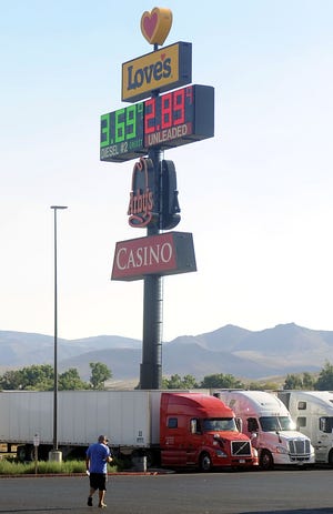 A trucker walks to his rig, parked at a truck stop in Fernley.