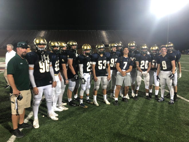 Head coach Mike Esplin and members of the Snow Canyon Warriors football team following a 35-29 overtime victory over Taylorsville.