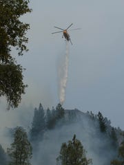 A helicopter drops water on the ridge near Bollibokka Club along the McCloud River on Saturday morning, Aug. 18, 2018. The Hirz Fire is burning in that area. (Special to the Record Searchlight/Hung T. Vu)
