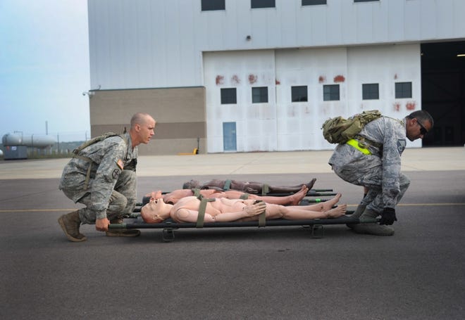 A Soldier and an Airman pick up a patient litter during a training exercise at Patriot Warrior on Aug. 15, 2018 at Fort McCoy, Wisc. The training consisted of patient evacuation scenarios.