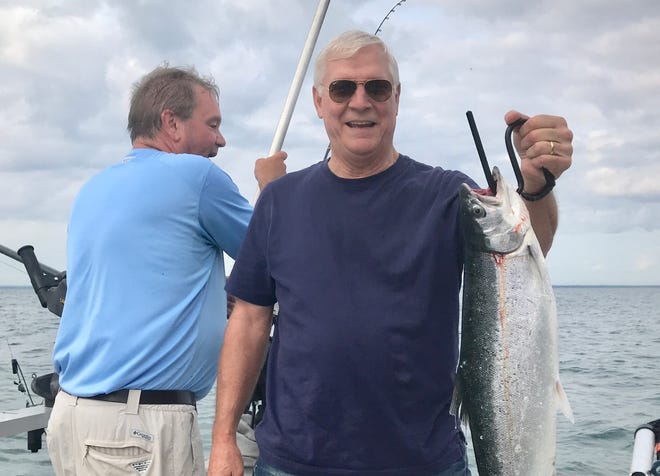 John Buttrill shows off a steelhead (rainbow) trout during the 25th annual Casting for Character sport fishing derby held in August on Lake Ontario. Capt. Jerry Felluca is in the background. The event helps support local Boys Scouts of America programs. Record catch rates were logged in 2018.