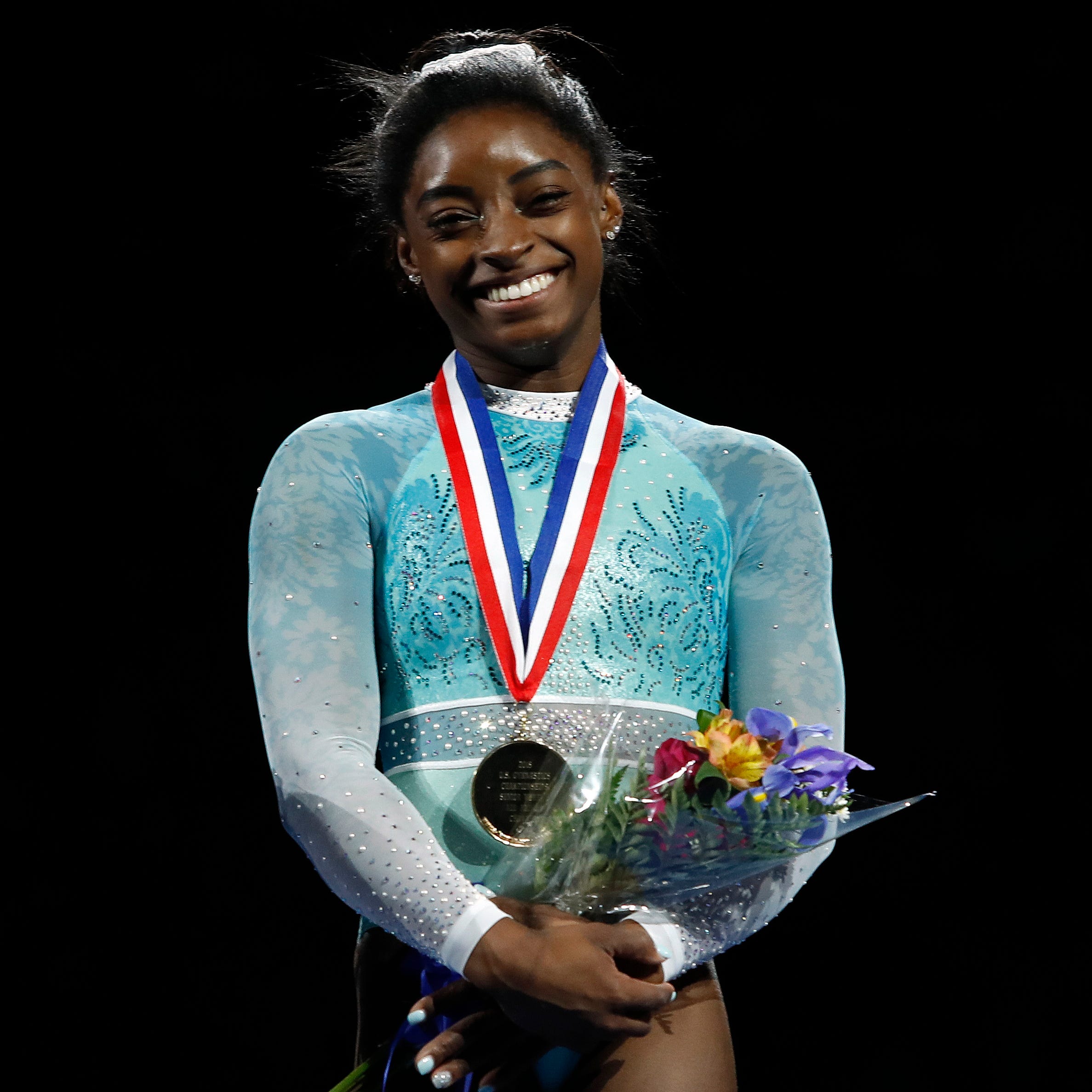 Simone Biles smiles after winning the women's all-around during the U.S. Gymnastics Championships.
